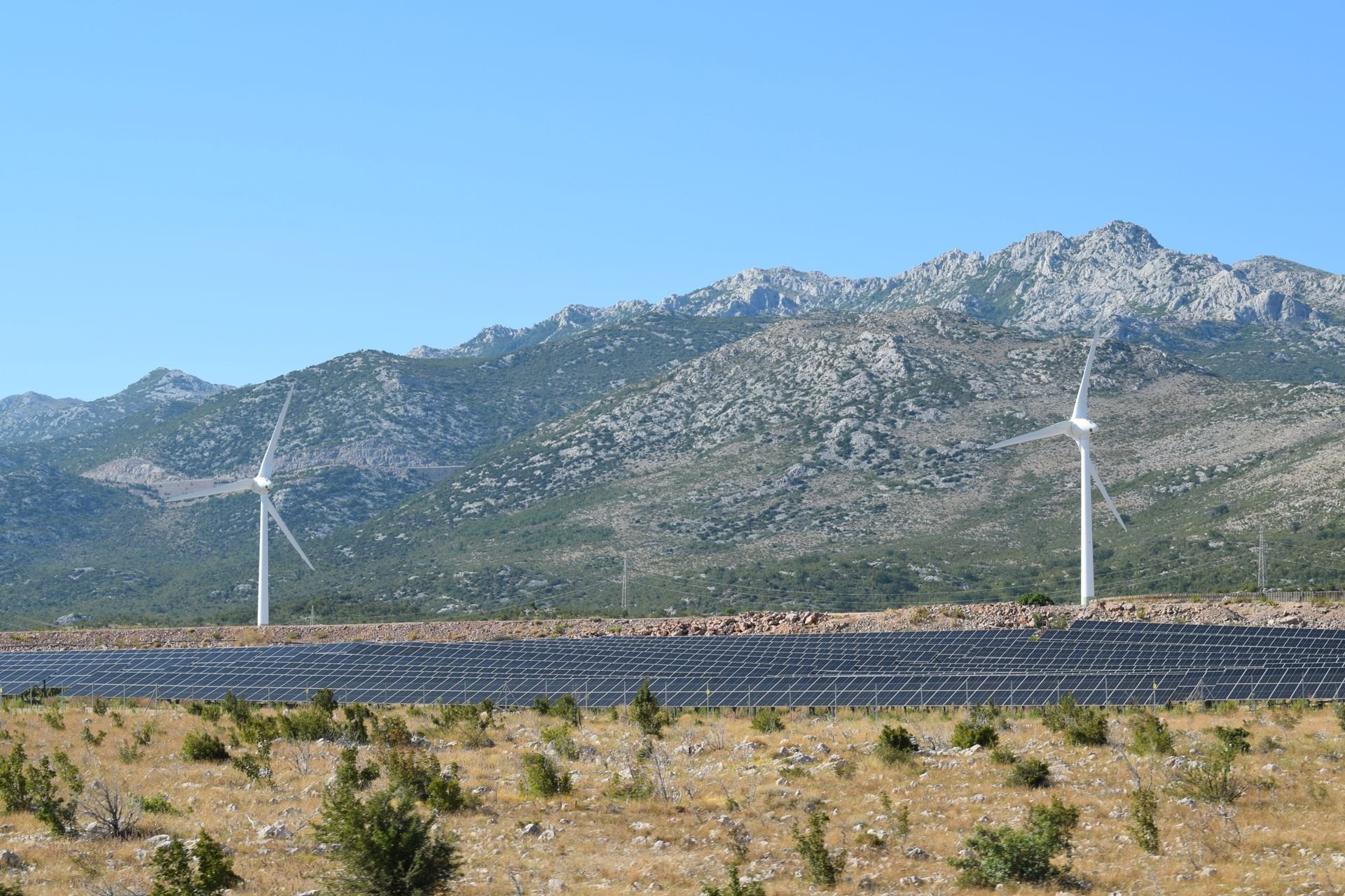 Wind turbines and solar panels on a hillside