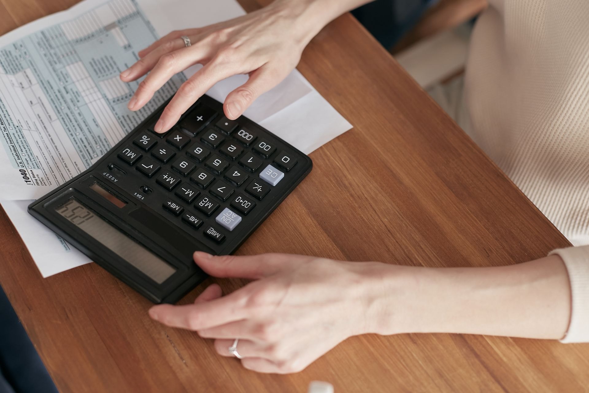 Person reviewing household bills with a calculator
